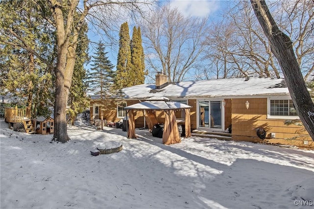 snow covered back of property featuring a gazebo