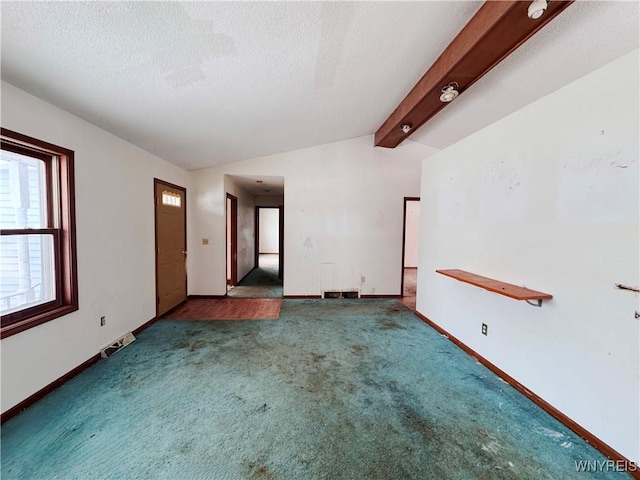 carpeted empty room with lofted ceiling with beams, baseboards, and a textured ceiling