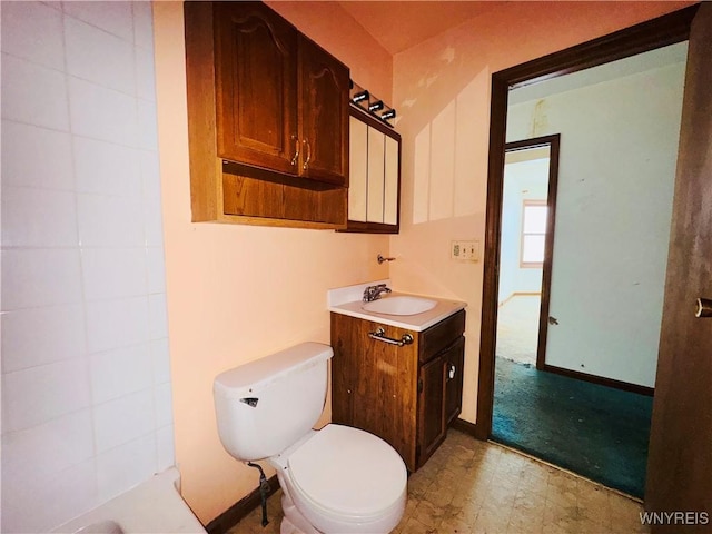 full bath with toilet, baseboards, vanity, and tile patterned floors