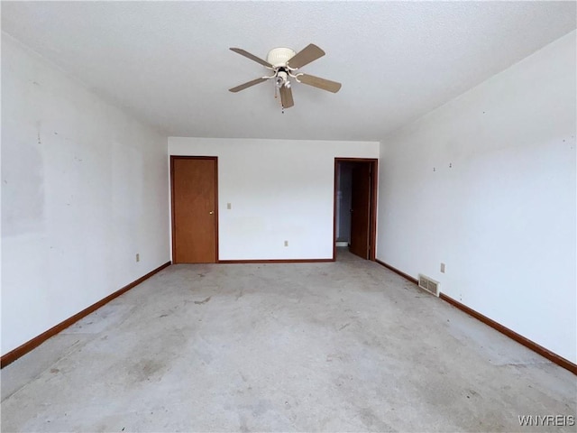 empty room with a ceiling fan, light colored carpet, visible vents, and baseboards