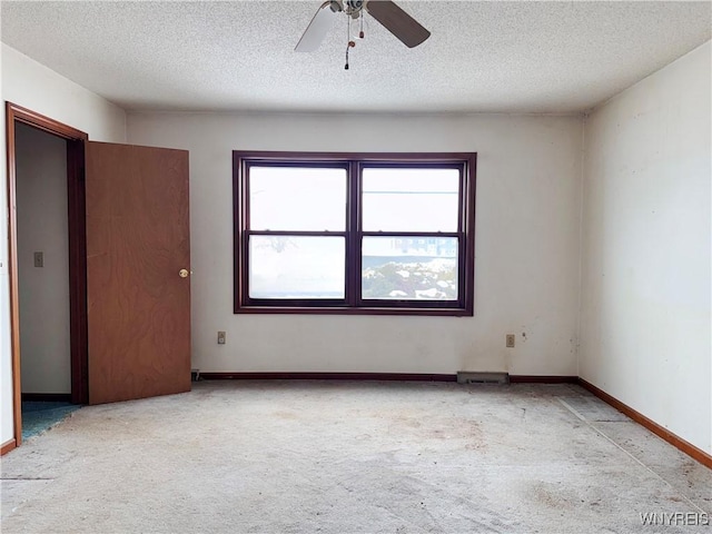 unfurnished room with baseboards, a textured ceiling, and light colored carpet