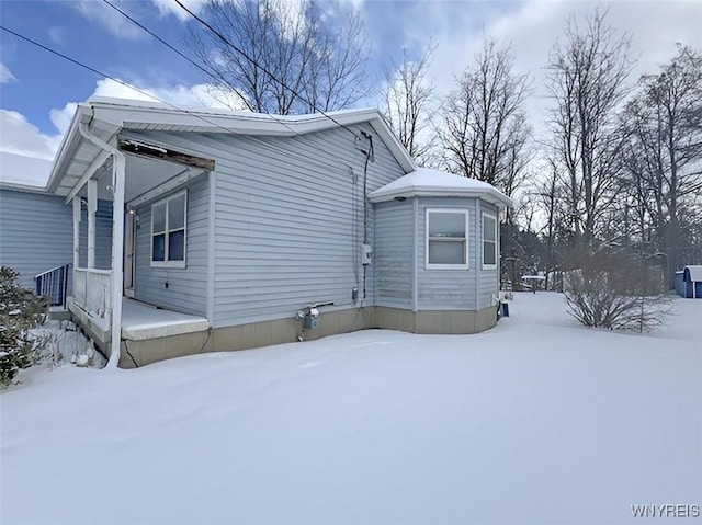 view of snow covered exterior featuring covered porch