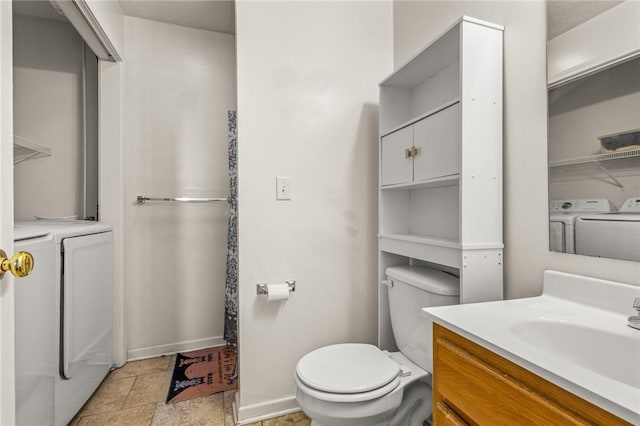 bathroom featuring vanity, toilet, and washer and dryer