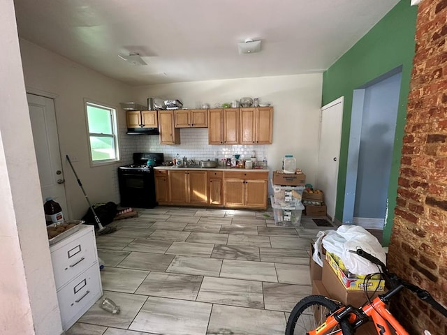 kitchen featuring tasteful backsplash, sink, and black gas range