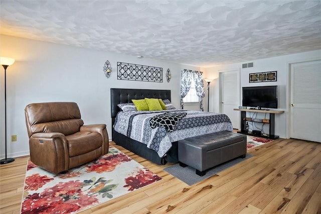 bedroom featuring hardwood / wood-style floors and a textured ceiling