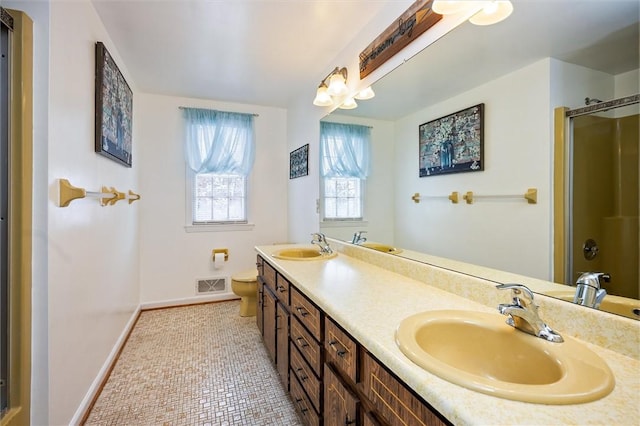 bathroom featuring vanity, toilet, a shower with shower door, and tile patterned flooring