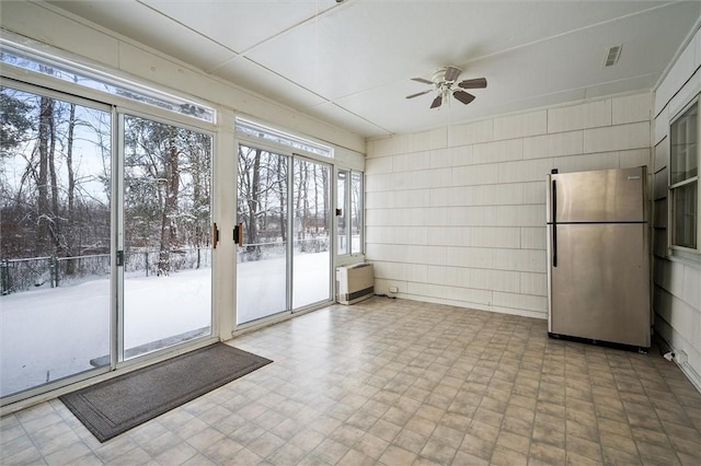 unfurnished sunroom featuring a wealth of natural light and ceiling fan