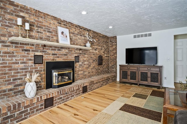 living room featuring hardwood / wood-style floors, a fireplace, and a textured ceiling