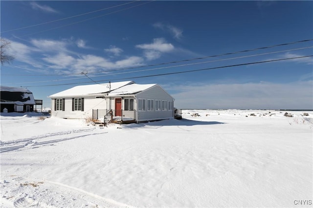 view of snow covered back of property