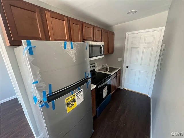 kitchen with stainless steel appliances, dark hardwood / wood-style floors, and sink