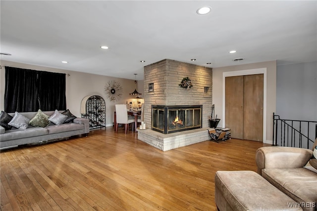 living room featuring wood-type flooring and a brick fireplace