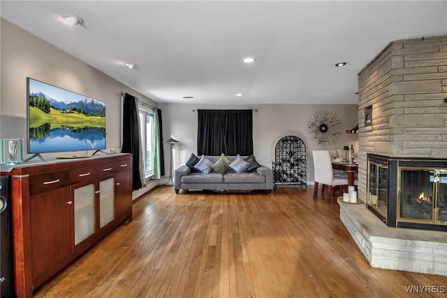 unfurnished living room featuring a stone fireplace and light hardwood / wood-style flooring