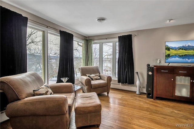 living area featuring a baseboard radiator and light wood-type flooring