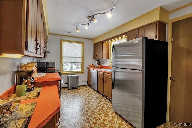 kitchen with ornamental molding, stainless steel appliances, and a baseboard heating unit