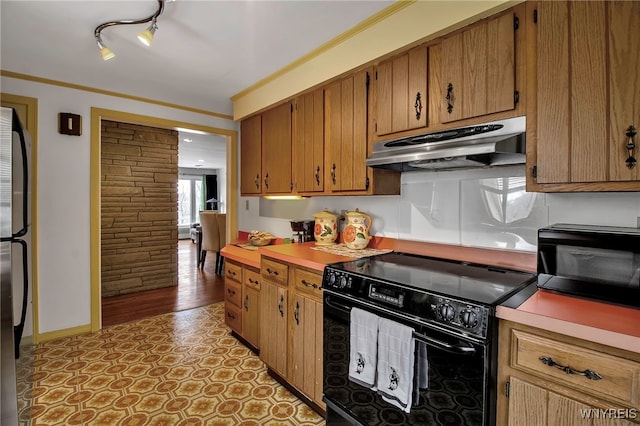 kitchen featuring crown molding, stainless steel refrigerator, and black range with electric cooktop