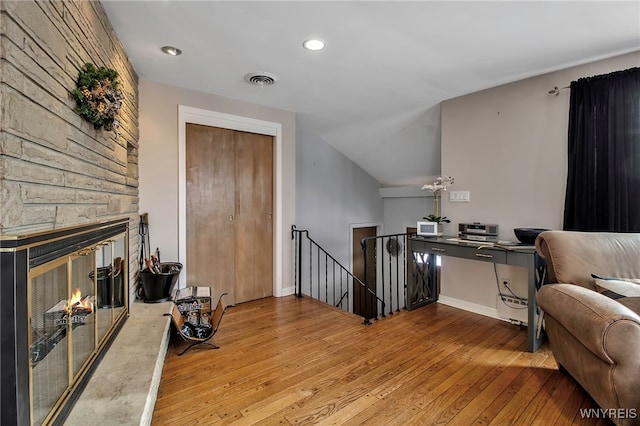 interior space featuring a fireplace, vaulted ceiling, and light hardwood / wood-style flooring