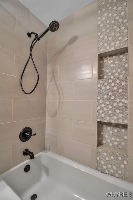 bathroom featuring tiled shower / bath