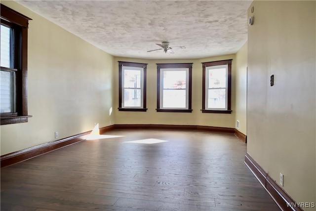 spare room with dark hardwood / wood-style floors and a textured ceiling