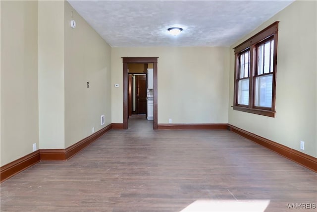 empty room with hardwood / wood-style flooring and a textured ceiling