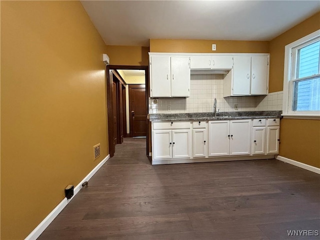 kitchen featuring white cabinetry, decorative backsplash, and dark hardwood / wood-style flooring