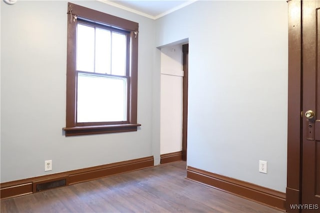 spare room featuring ornamental molding and wood-type flooring