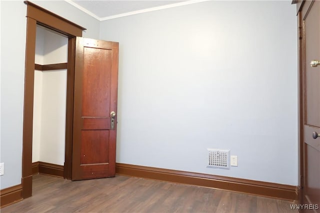 spare room featuring hardwood / wood-style floors and ornamental molding