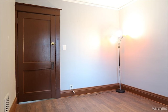 spare room with hardwood / wood-style flooring and ornamental molding