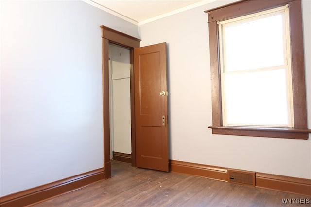 unfurnished bedroom with dark wood-type flooring and ornamental molding