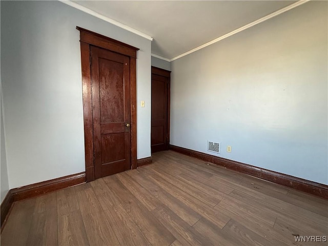 unfurnished bedroom with crown molding and hardwood / wood-style floors