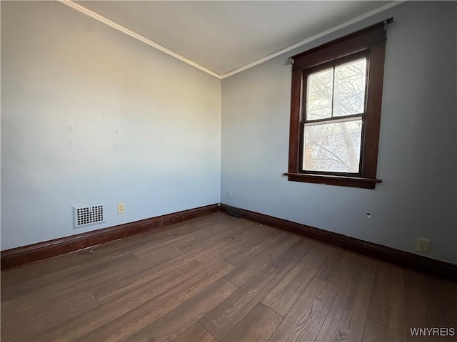 empty room featuring crown molding and wood-type flooring