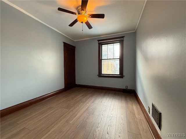 unfurnished room featuring crown molding, wood-type flooring, and ceiling fan