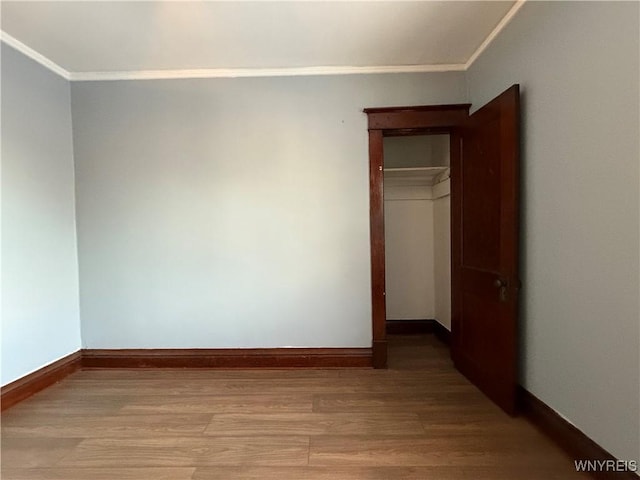 unfurnished bedroom featuring hardwood / wood-style flooring and ornamental molding