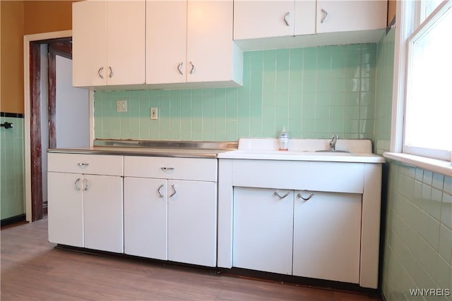 kitchen with tasteful backsplash and white cabinetry