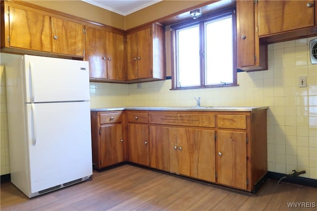 kitchen with white fridge, sink, and light wood-type flooring