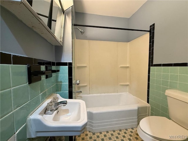 full bathroom with tile walls, sink, shower / tub combination, and toilet