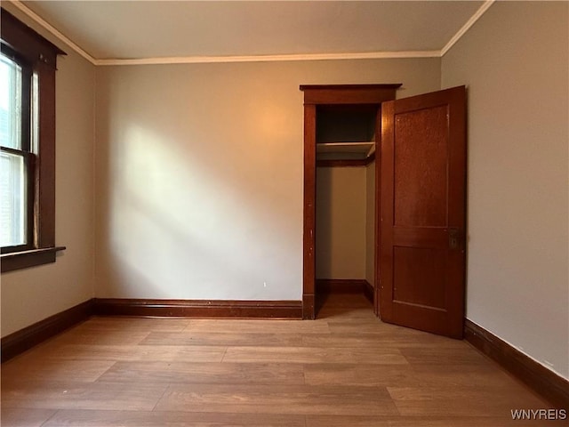 unfurnished bedroom featuring ornamental molding, light hardwood / wood-style floors, and a closet