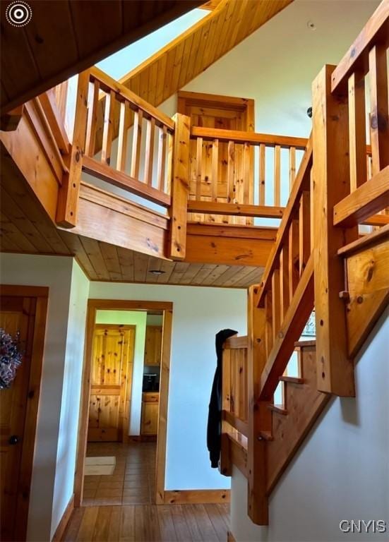 stairway featuring lofted ceiling and wood-type flooring