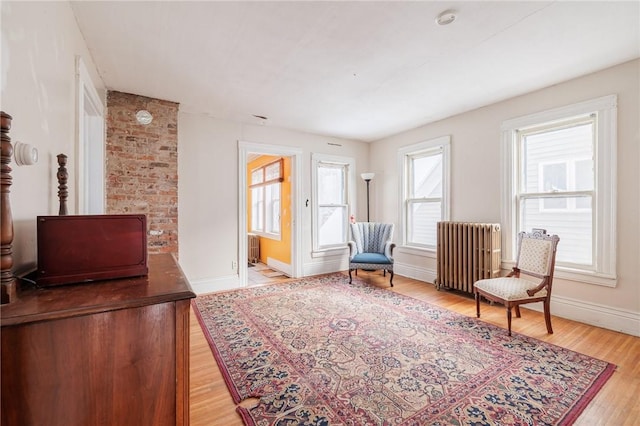 sitting room featuring radiator heating unit and light wood-type flooring