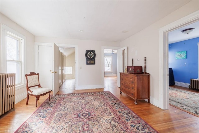 hallway featuring radiator and light hardwood / wood-style floors