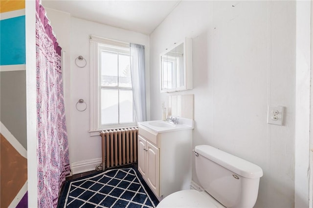 bathroom with vanity, radiator heating unit, and toilet