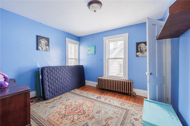 bedroom with radiator and light wood-type flooring