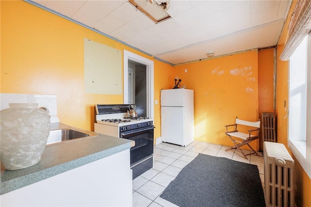 kitchen with white appliances, radiator, and light tile patterned floors