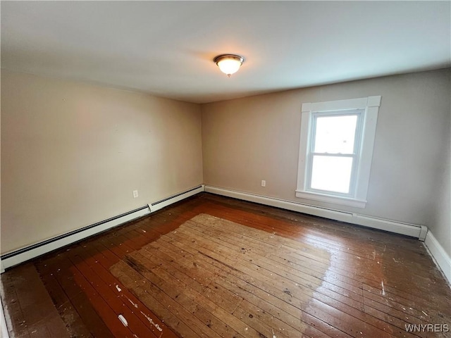 spare room with a baseboard radiator and dark wood-type flooring