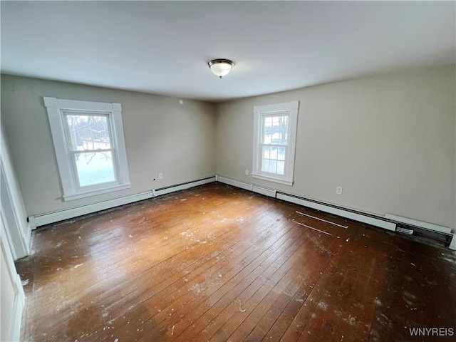 empty room with a baseboard radiator and dark hardwood / wood-style floors