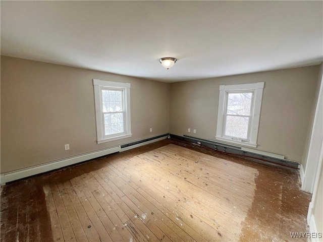 unfurnished room featuring hardwood / wood-style flooring and a baseboard heating unit