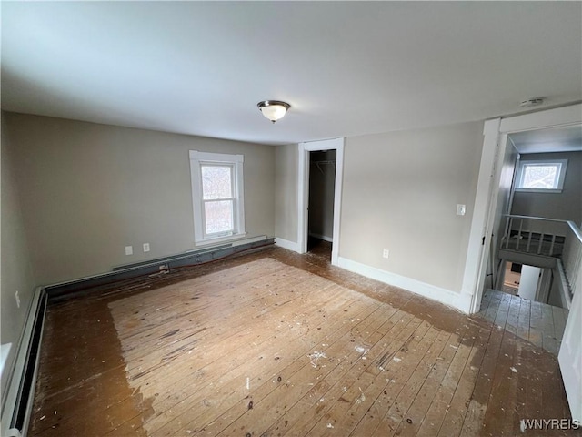 spare room with a baseboard radiator, hardwood / wood-style floors, and a wealth of natural light