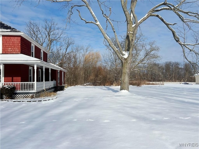 yard layered in snow with a porch