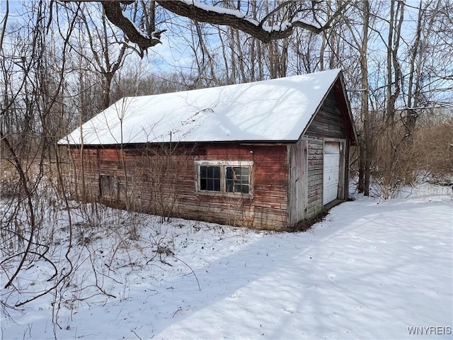 snow covered structure featuring a garage