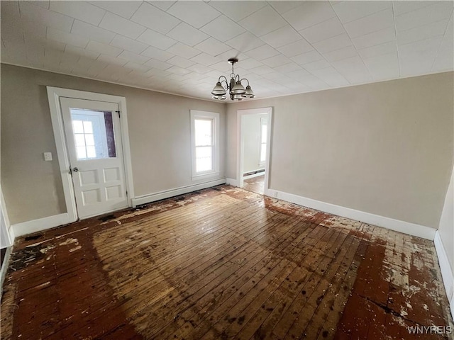 unfurnished dining area with hardwood / wood-style flooring, a notable chandelier, and a baseboard heating unit