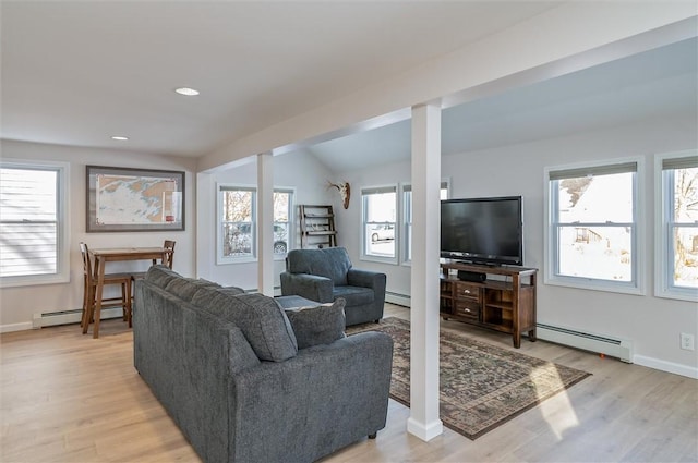 living room featuring lofted ceiling, light hardwood / wood-style floors, and baseboard heating